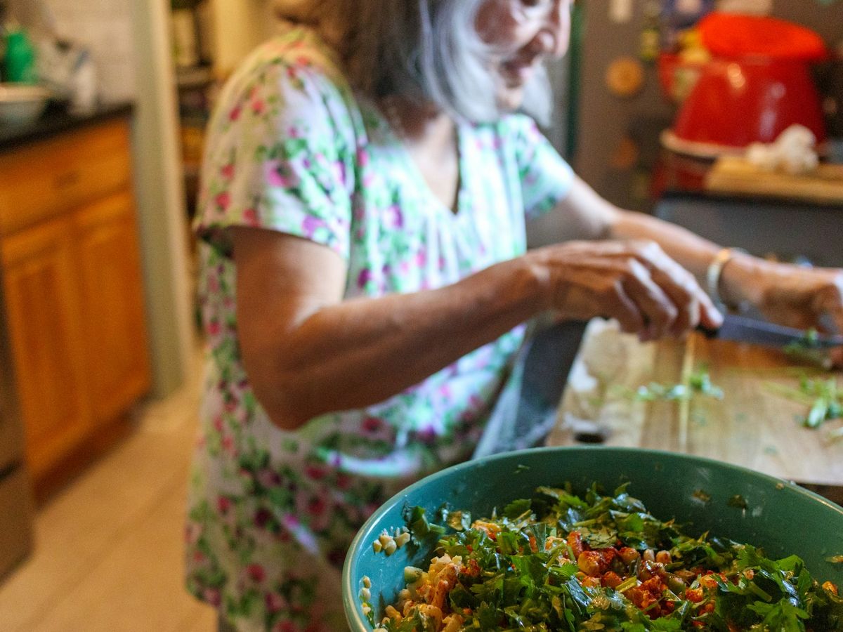 Mani che preparano un’insalata fresca in cucina
